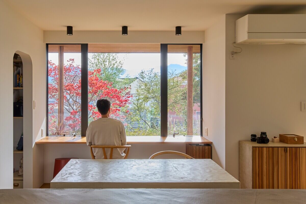 窓から外を眺める男性